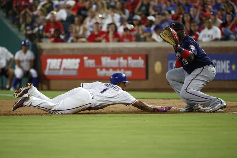 Texas Rangers shortstop Elvis Andrus (1) slides back into first after trying to steal second...