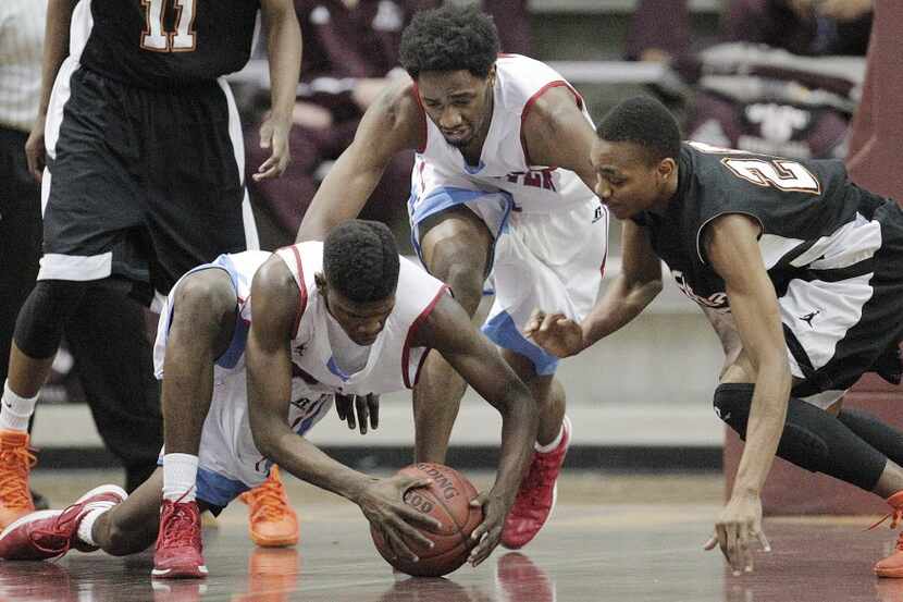 Carter's Dazahoa Miles (23) and Jeremy Combs (1) battle Lancaster's Antione Taylor (20) for...
