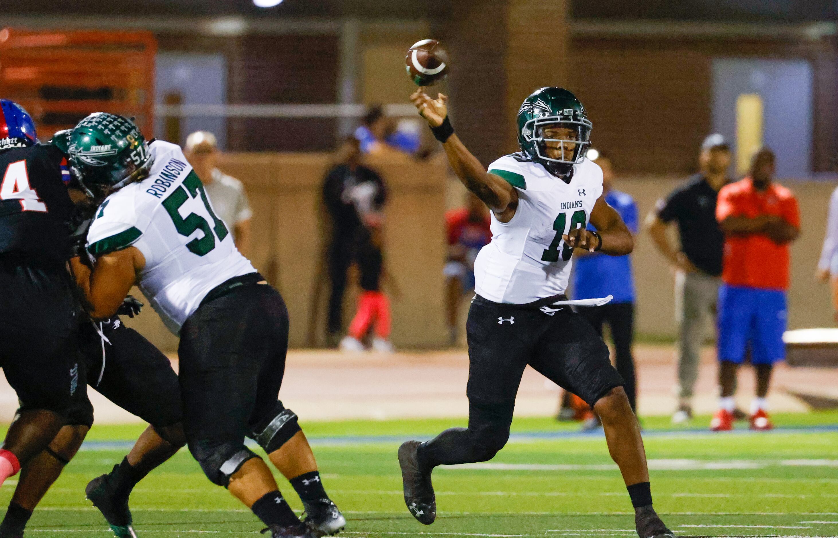 Waxahachie quarter back Roderick Hartsfield, Jr. (10) moves around defenders to throw a pass...
