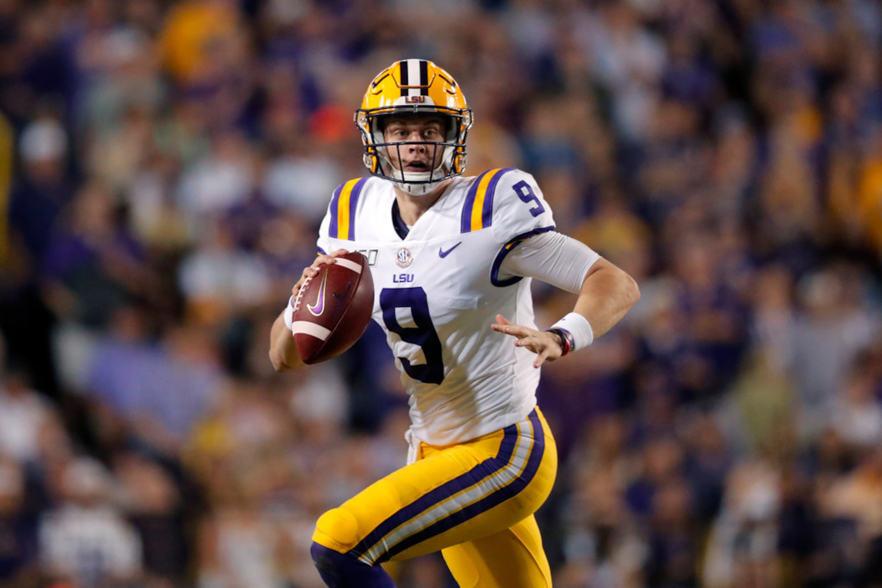 LSU quarterback Joe Burrow (9) scrambles during the first half of an NCAA college football...