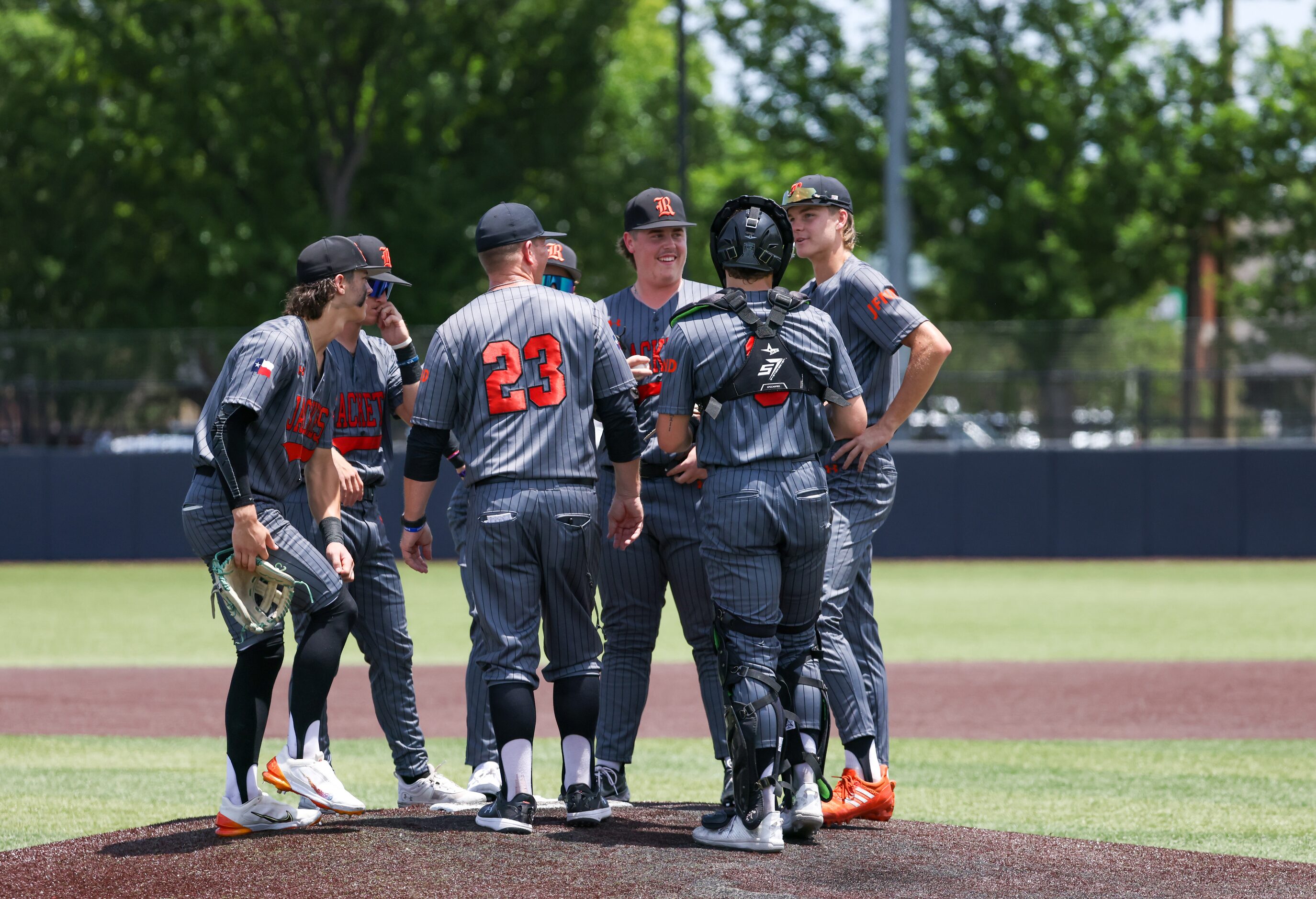 Rockwall players gather on the mound to talk between pitches during an area round game of...