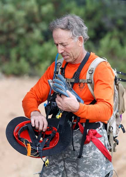 A member of the Tonto Rim Search and Rescue team gathers his gear during an operation along...