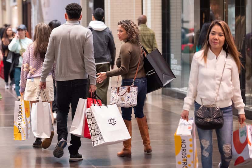 Shopper weighed down with bags at NorthPark Center during the long Thanksgiving weekend of...