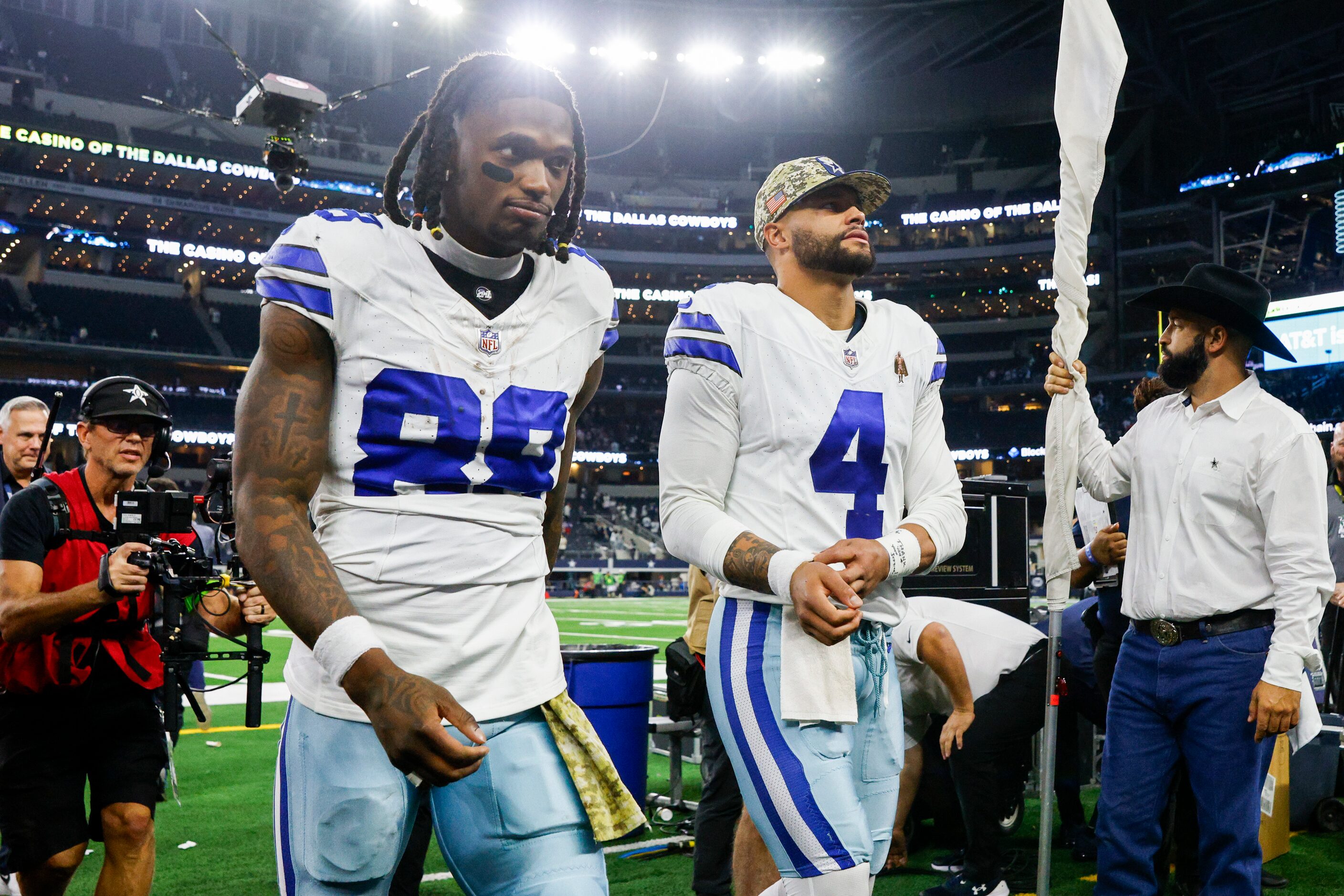 Dallas Cowboys wide receiver CeeDee Lamb (88) and quarterback Dak Prescott (4) walk off the...