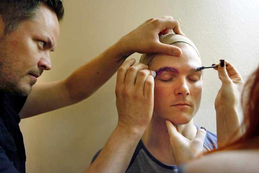 
Makeup and hair stylist Michael Moore flattens and smoothes Igneczi’s eyebrows with a glue...
