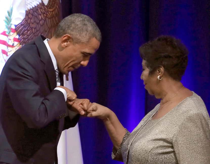 President Barack Obama fist-bumps with singer Aretha Franklin, who sang during a farewell...
