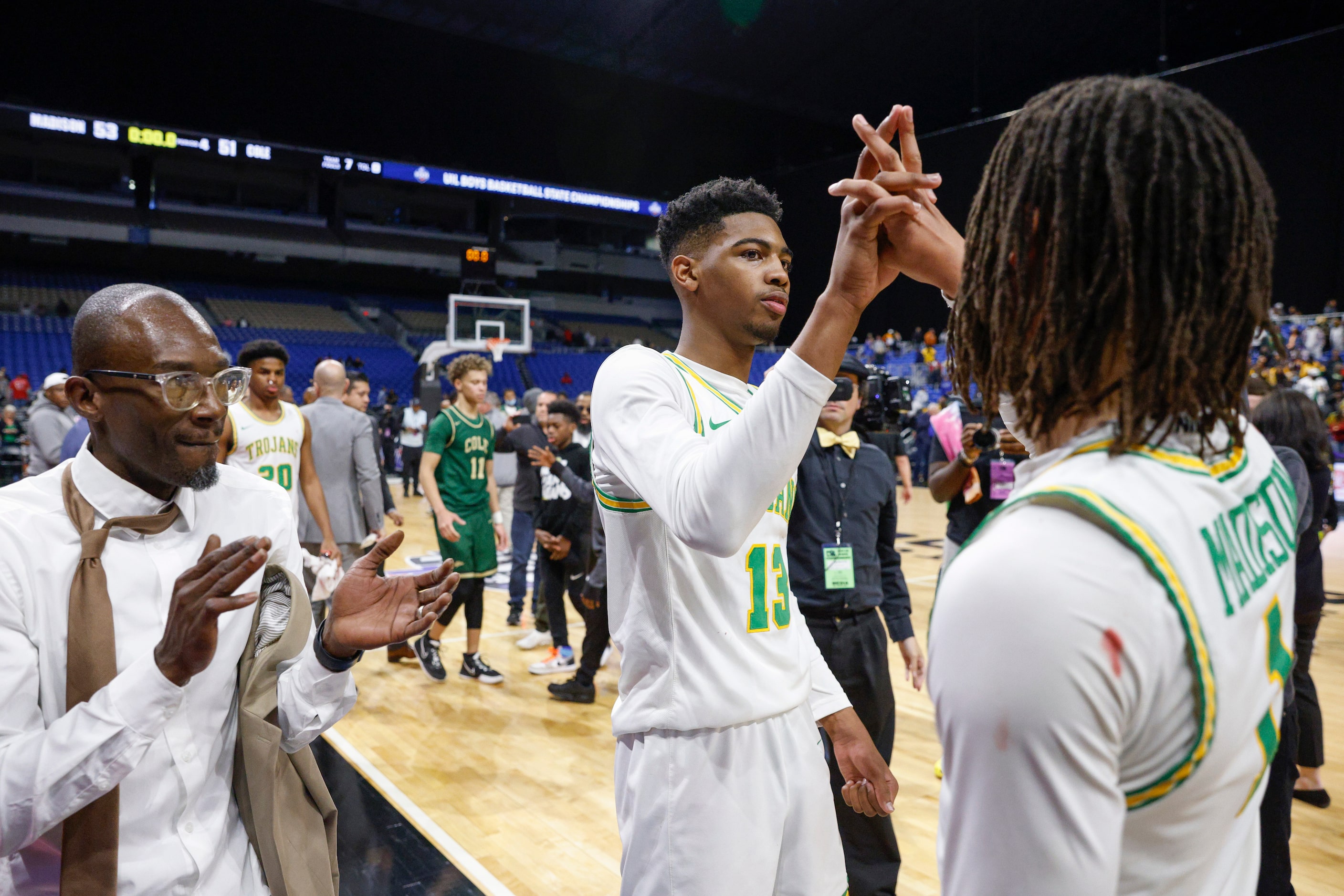 Madison forward Rodney Geter (13) and Madison guard Pierre Hunter (1) shake hands alongside...