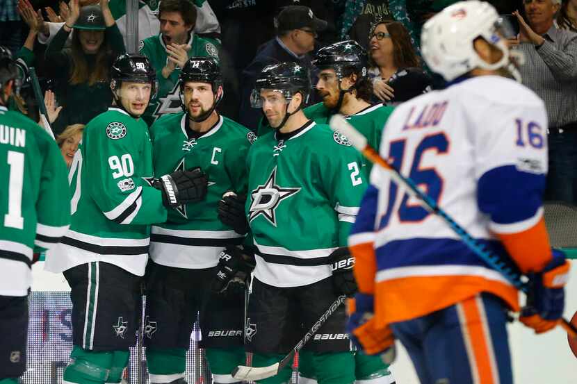 Dallas Stars left wing Jamie Benn (14, center) is congratulated on his first period goal by...
