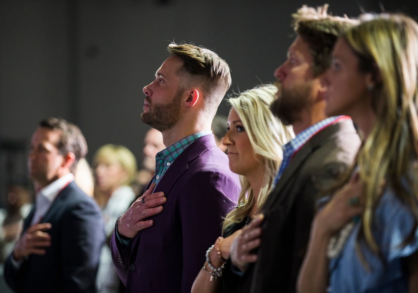 Founder and owner David Vobora places his hand over his heart as the national anthem plays...