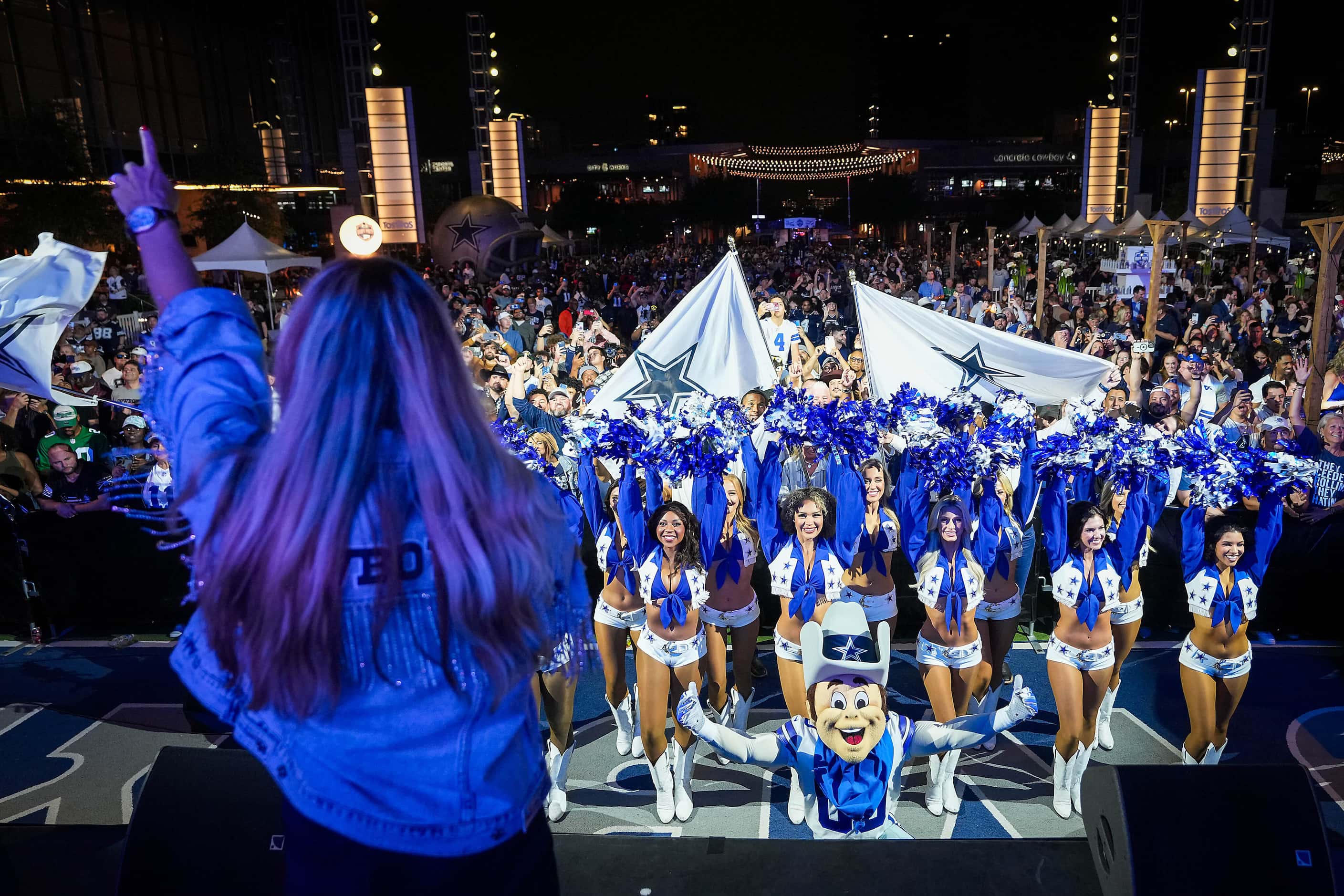 Dallas Cowboys fans, cheerleaders, and mascot Rowdy await the team’s first round pick in the...