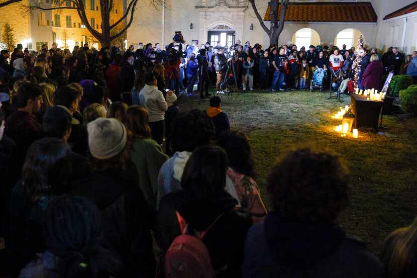 Community members and Paschal High School students gather during a candlelight vigil for...