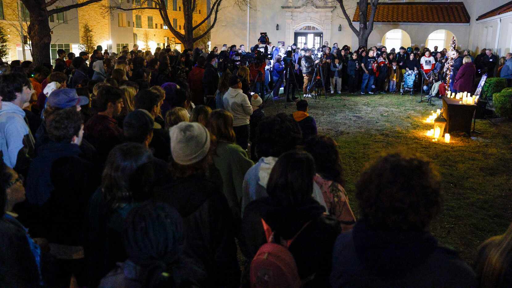 Community members and Paschal High School students gather during a candlelight vigil for...