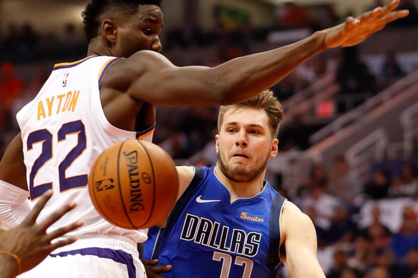 Dallas Mavericks guard Luka Doncic (77) dishes around Phoenix Suns center Deandre Ayton (22)...