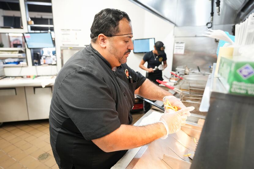Owner Alf Gonzalez works in the kitchen of Fatburger at the Allen Premium Outlets on Wednesday.