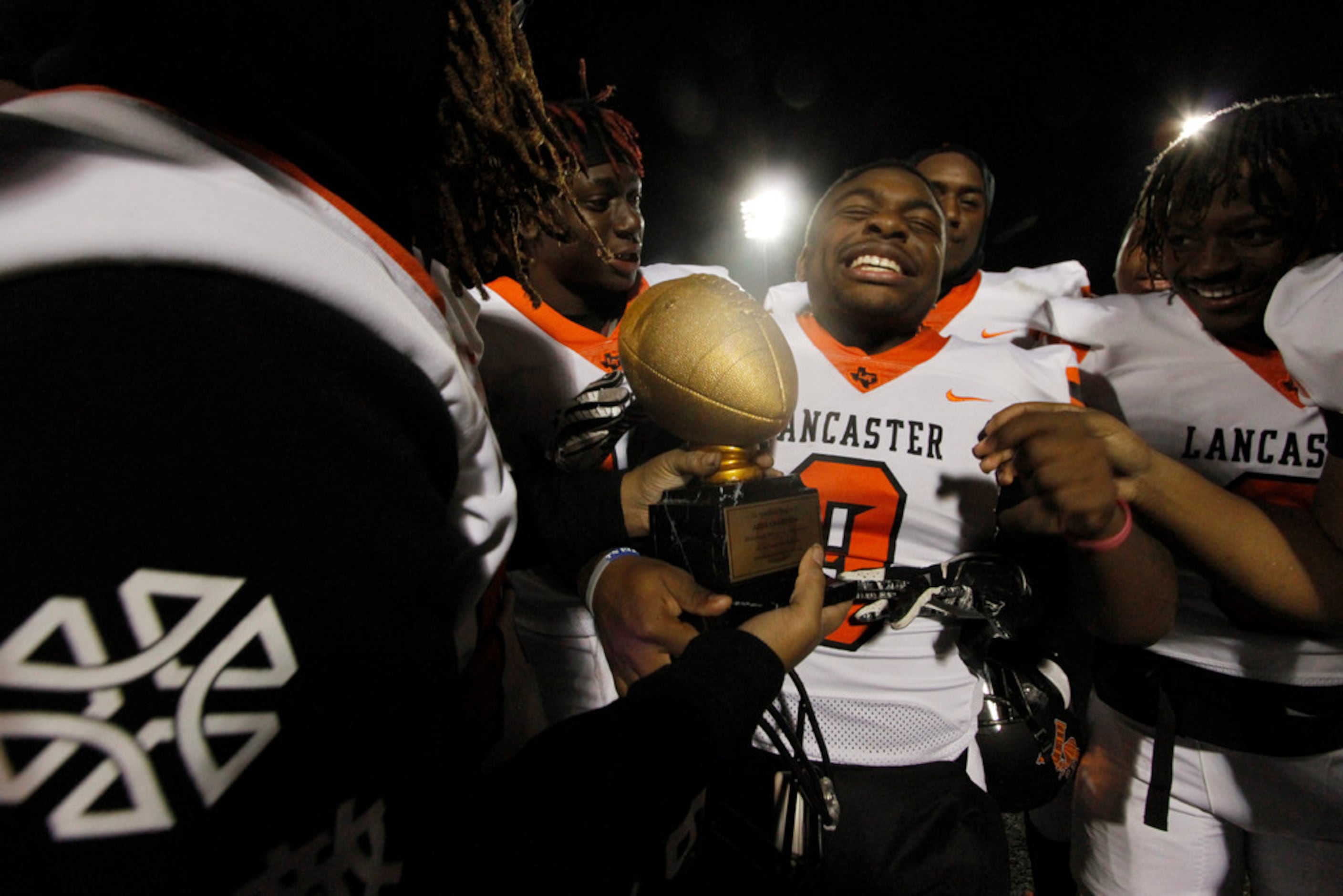 Lancaster Tigers linebacker Jaylen Estelle (9) soaks in the moment as teammates move in to...