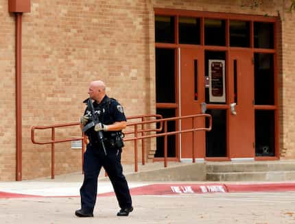 An Irving police officer searches the Stephen F. Austin Middle School campus in Irving,...