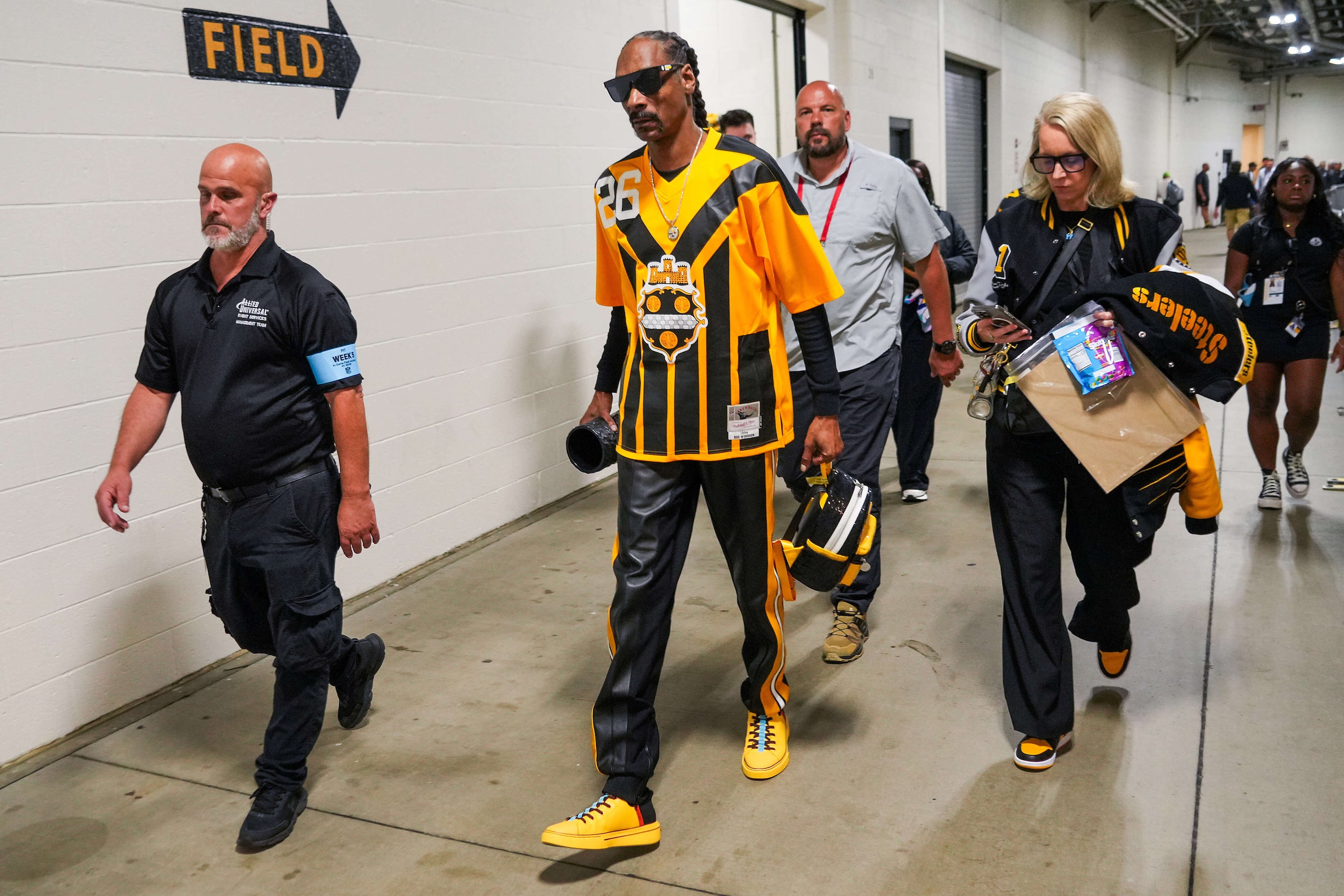 Rapper Snoop Dogg walks from the field before an NFL football game between the Pittsburgh...