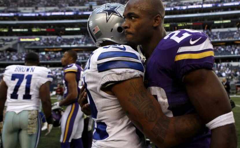 Cowboys Orlando Scandrick, left, hugs Vikings running back Adrian Peterson during the...