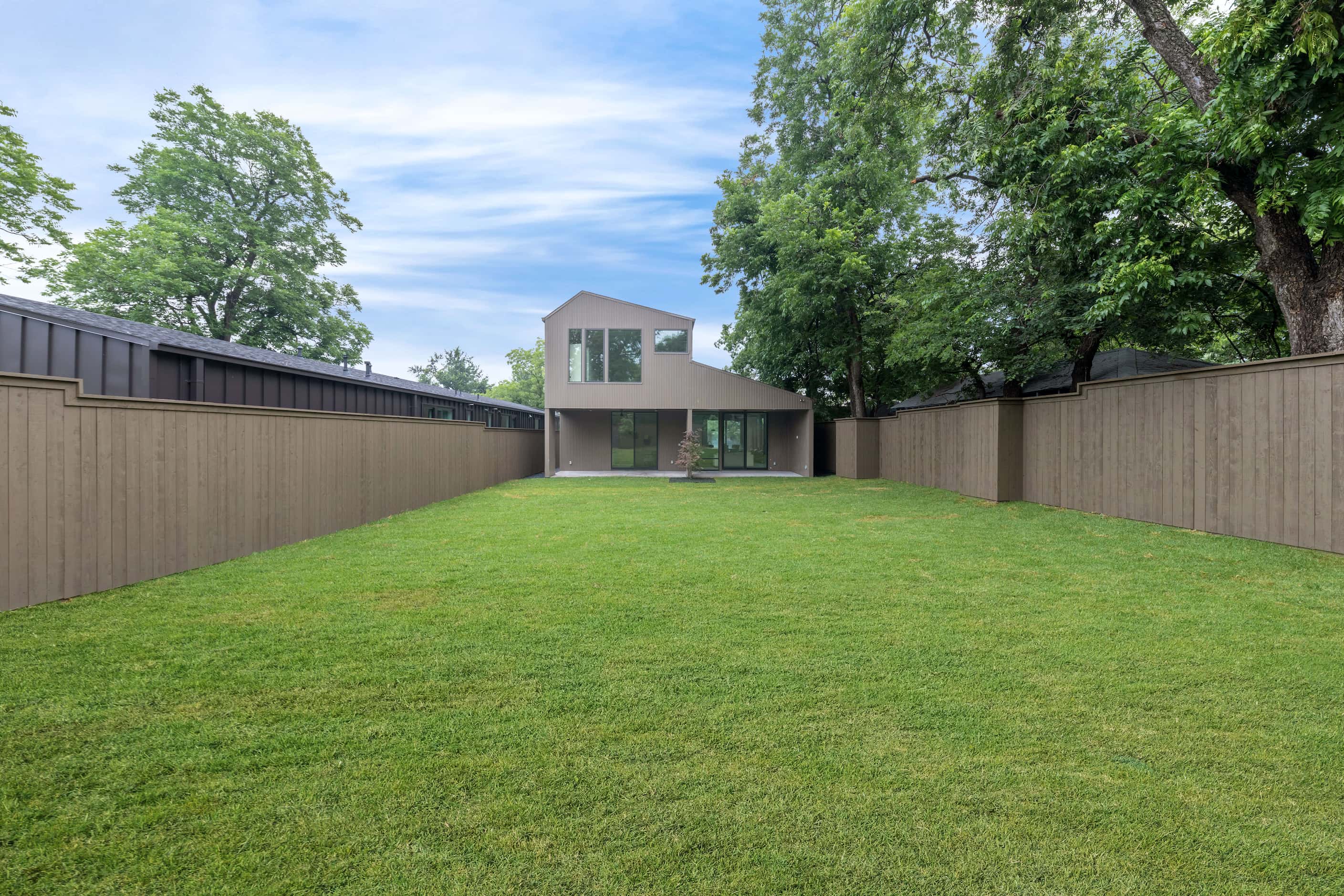 Exterior photo of contemporary home with metal exterior, large grassy area