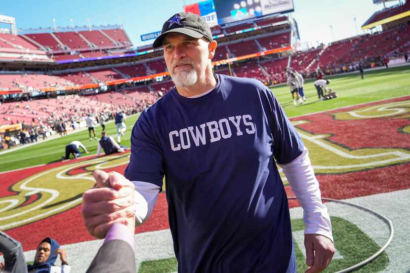 Dallas Cowboys defensive coordinator Dan Quinn greets people on the sidelines as the teams...