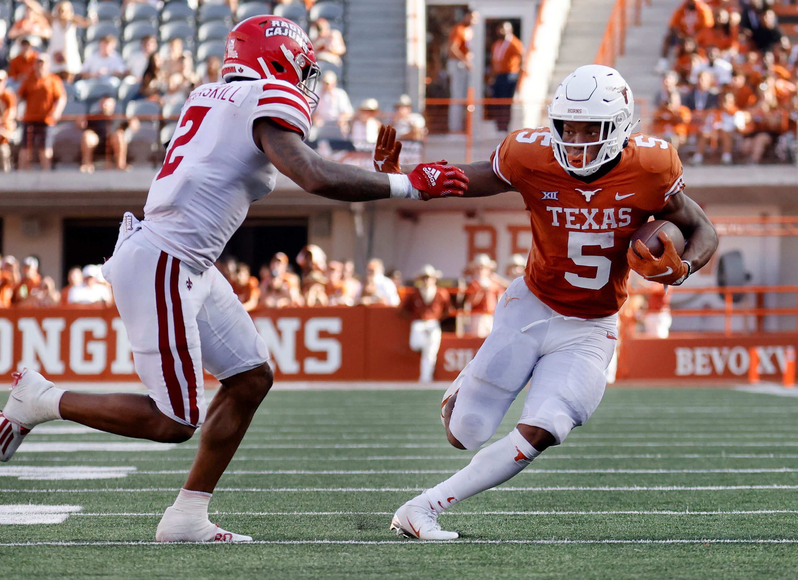 Texas Longhorns running back Bijan Robinson (5) gives a stiff arm to Louisiana-Lafayette...