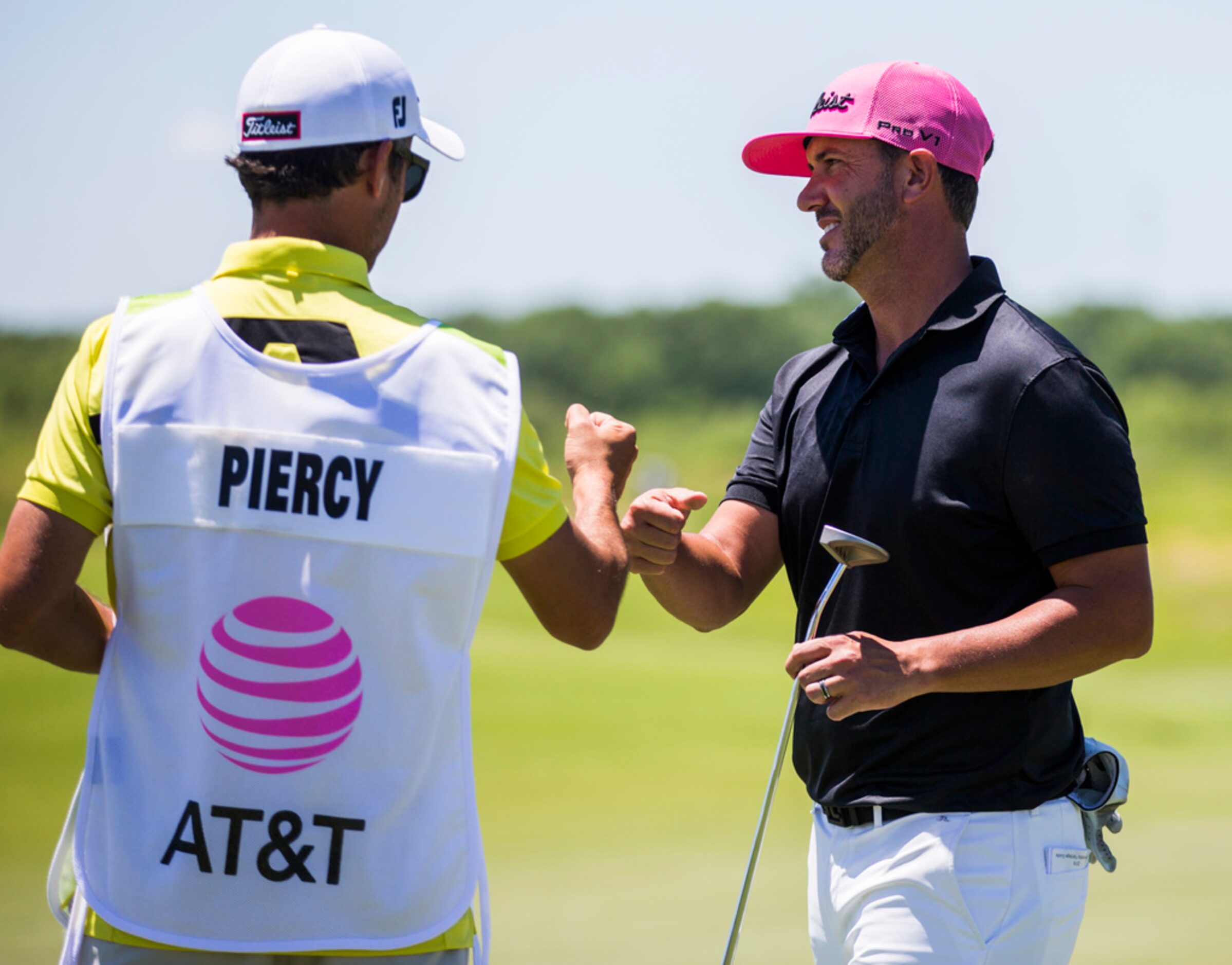 Scott Piercy celebrates with his caddie, Jose Campra, after sinking a putt on hole 3 during...