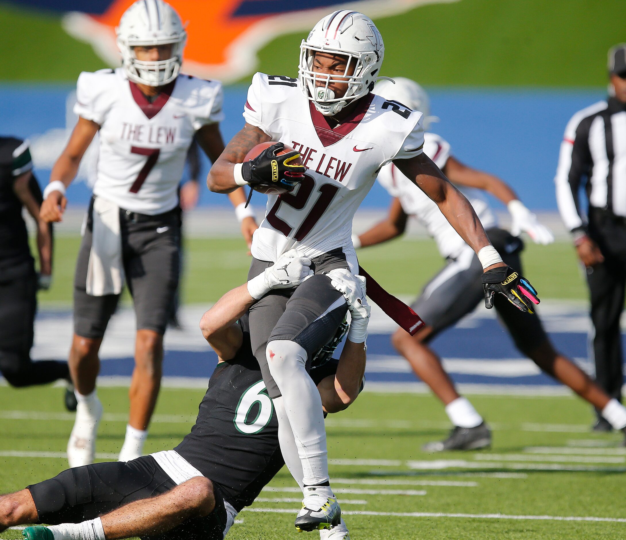 Lewisville High School running back Viron Ellison (21) tries to break free from Prosper High...