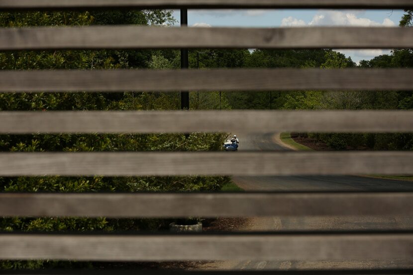 Seen through the gate at the entrance, golf carts are used to shuttle guests from the...