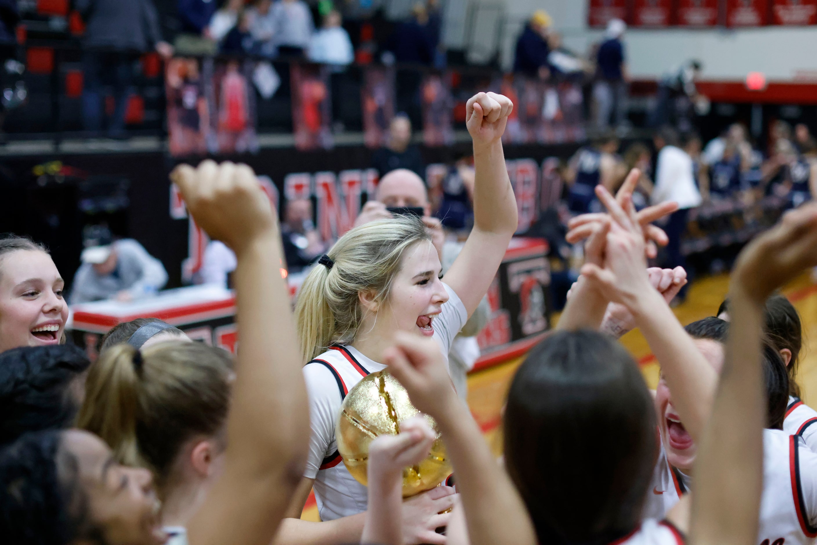 Coppell’s Jules LaMendola, center, celebrates with the trophy and the team after they...