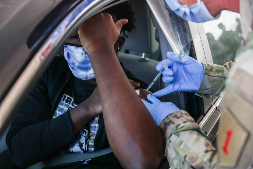 Quincy Williams, 20, receives the 250,000th vaccine provided by Dallas County at Fair Park...