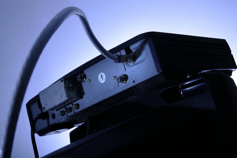 FILE - This May 30, 2007 file photo shows a cable box on top of a television in...