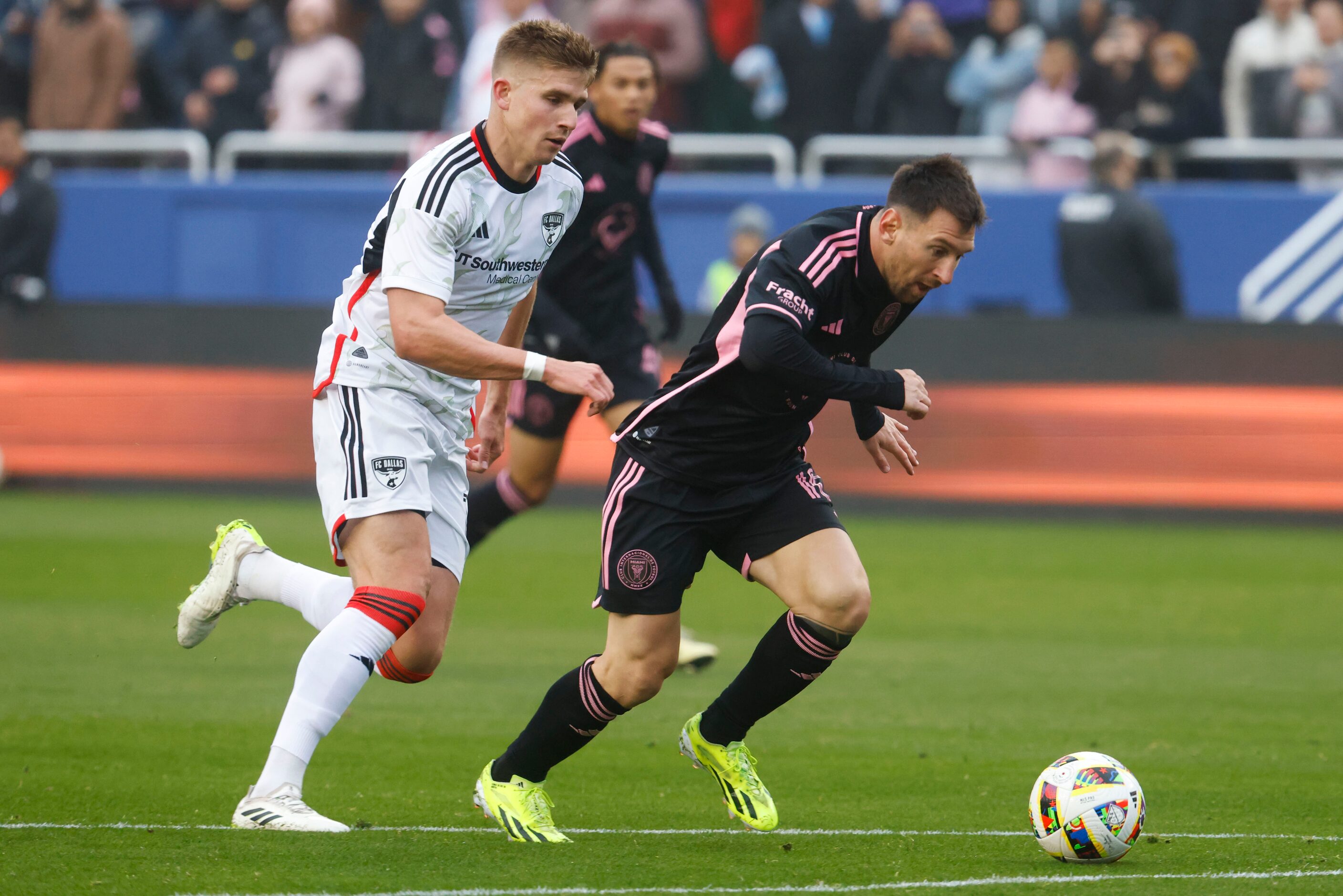 FC Dallas midfielder Liam Fraser (left) runs to stop Inter Miami forward Lionel Messi during...