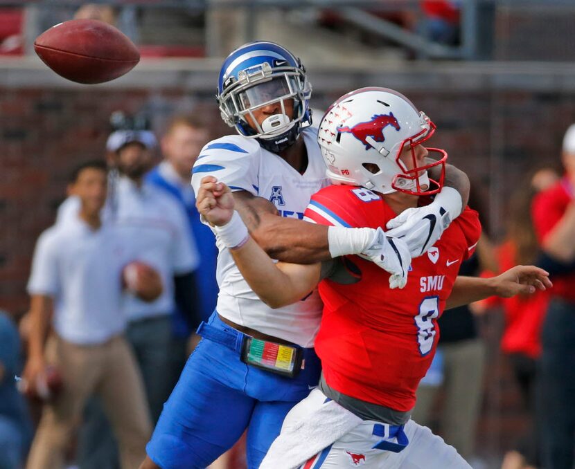 Memphis defensive back Arthur Maulet, left, hits SMU quarterback Ben Hicks, forcing a fumble...