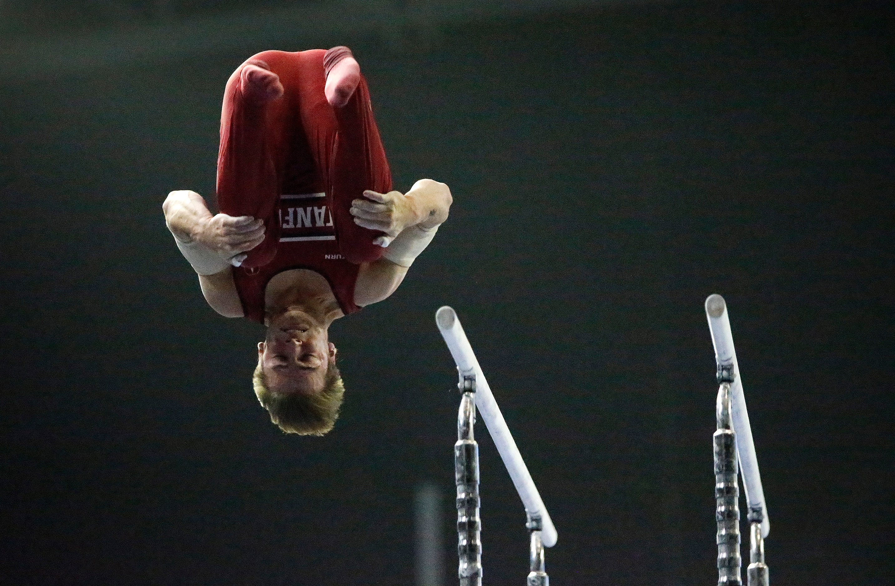 Curran Phillips of Stanford, dismounts from the parallel bars during the mens finals at the...