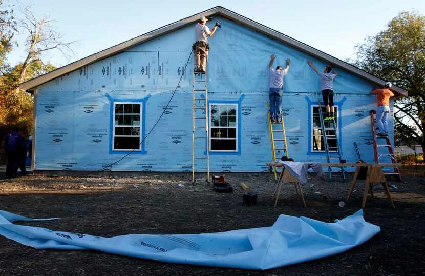 
Community members work on the Purple House Project in Celina, the 100th home built by North...