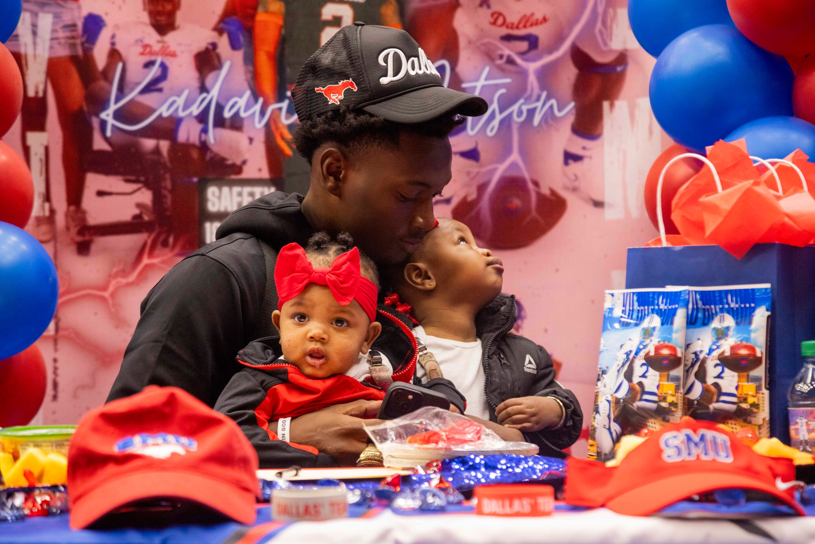 Safety Ka'Davion Dotson-Walker holds his nieces, 6-month-old Ka’Nyiah and Ka’Nyriah...