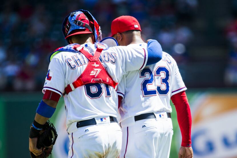 Texas Rangers catcher Robinson Chirinos (61) has a word with relief pitcher Jeremy Jeffress...