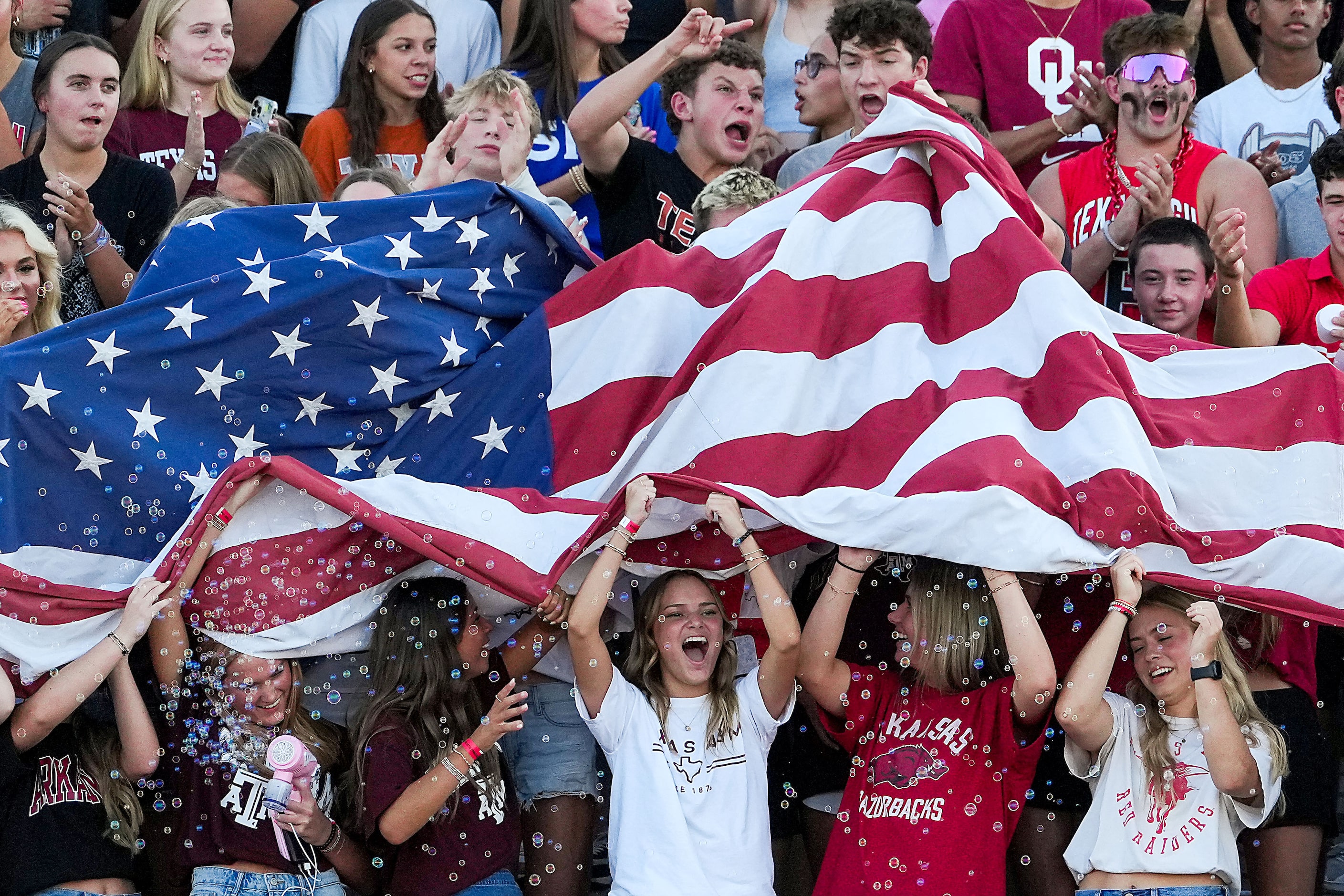 Rockwall-Heath students cheer as they unfurl the American flag for the national anthem...