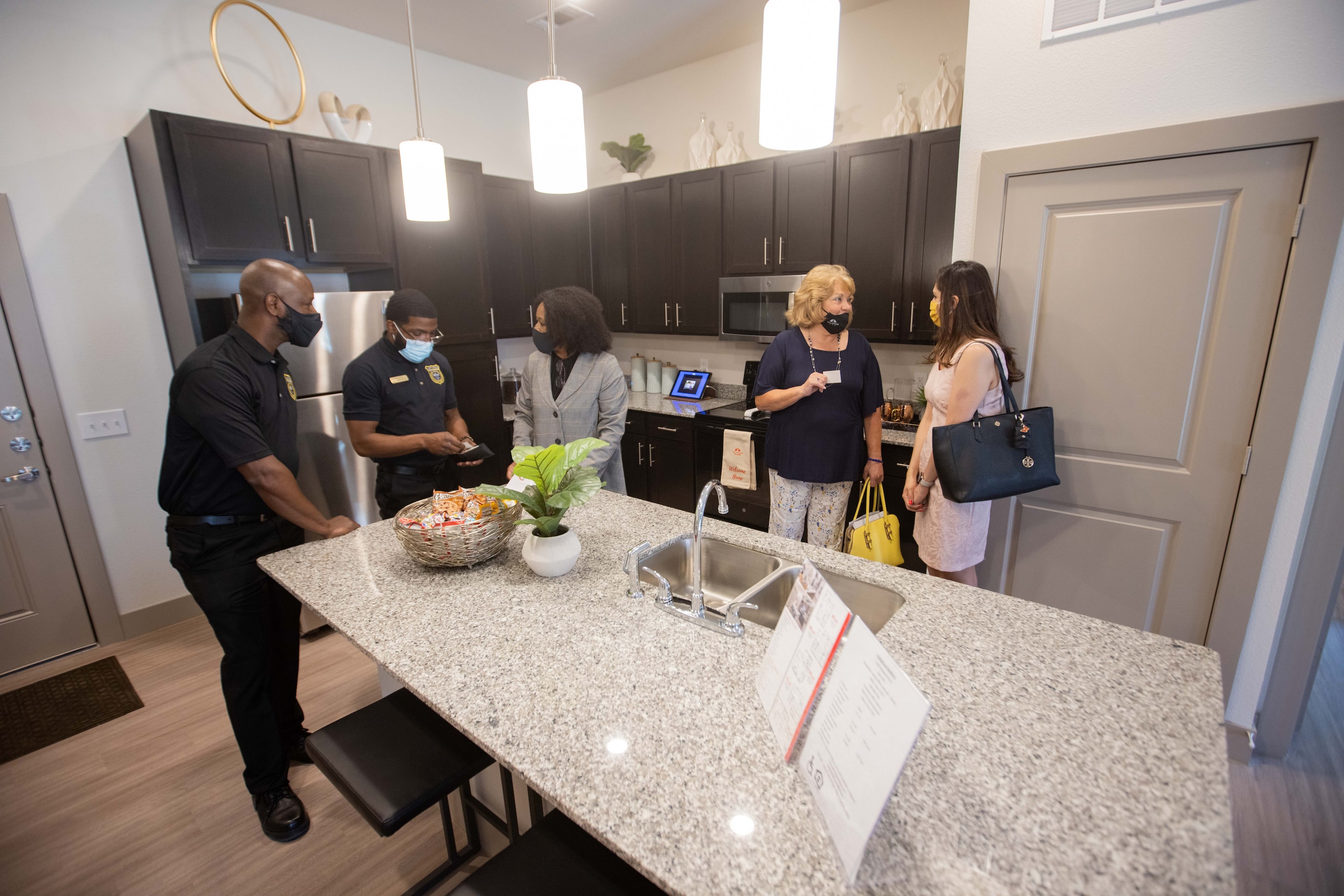 Palladium regional manager April West (center) leads a tour of a model apartment at...