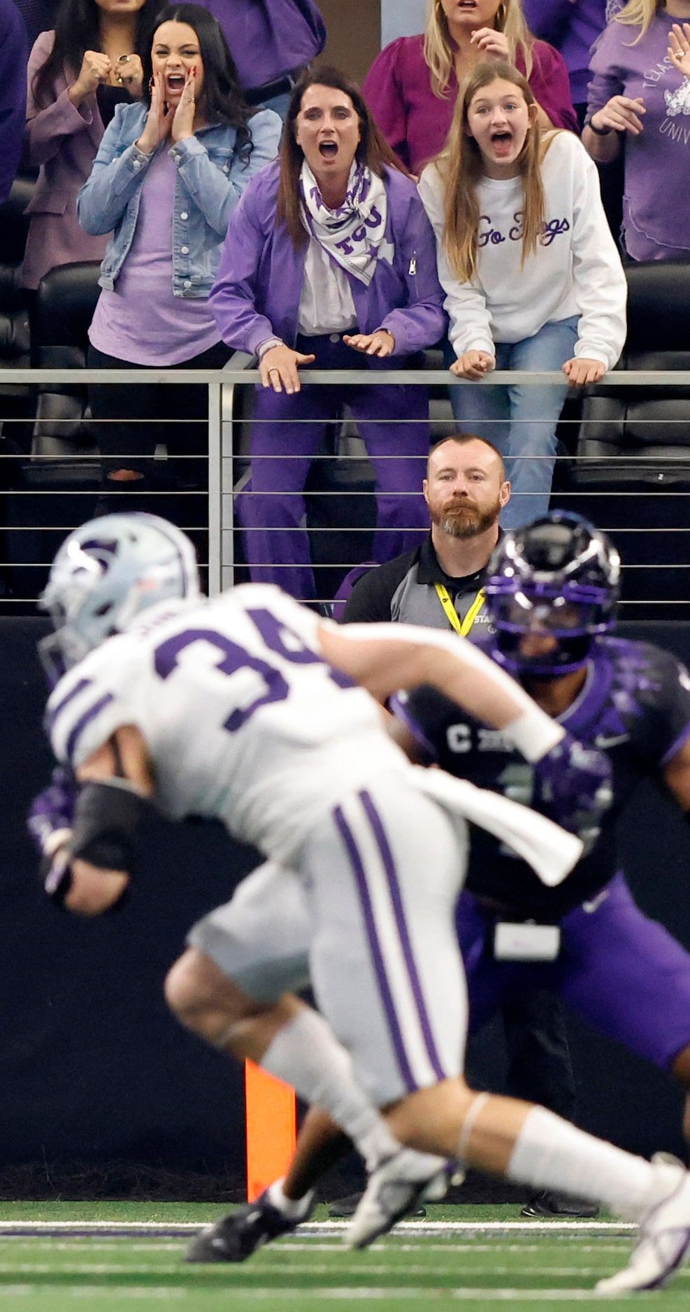 TCU Horned Frogs head coach Sonny Dykes’ wife Kate Golding (leaning on riling in purple...