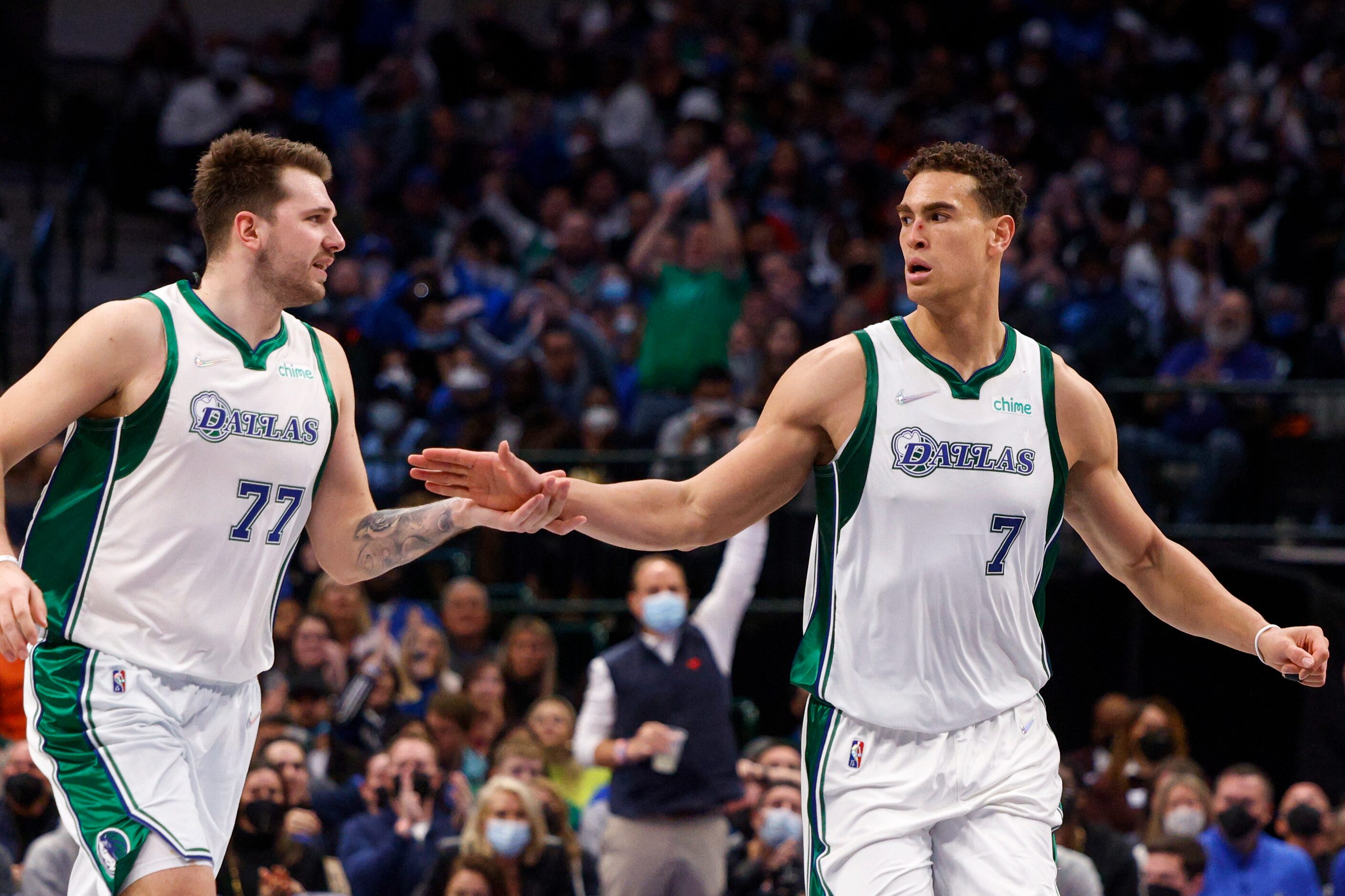 Dallas Mavericks guard Luka Doncic (77) high-fives Dallas Mavericks center Dwight Powell (7)...