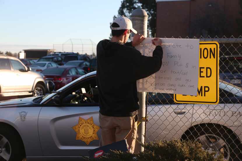 Chris Davis, a senior who plays basketball at Arapahoe High School, hangs a sign to raise...