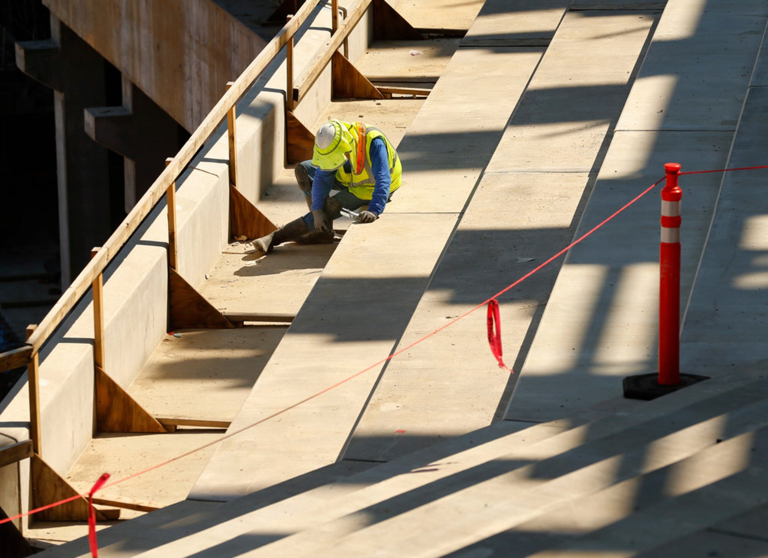 Hernando Castillo works on the main concourse seating area of the new Globe Life Field under...