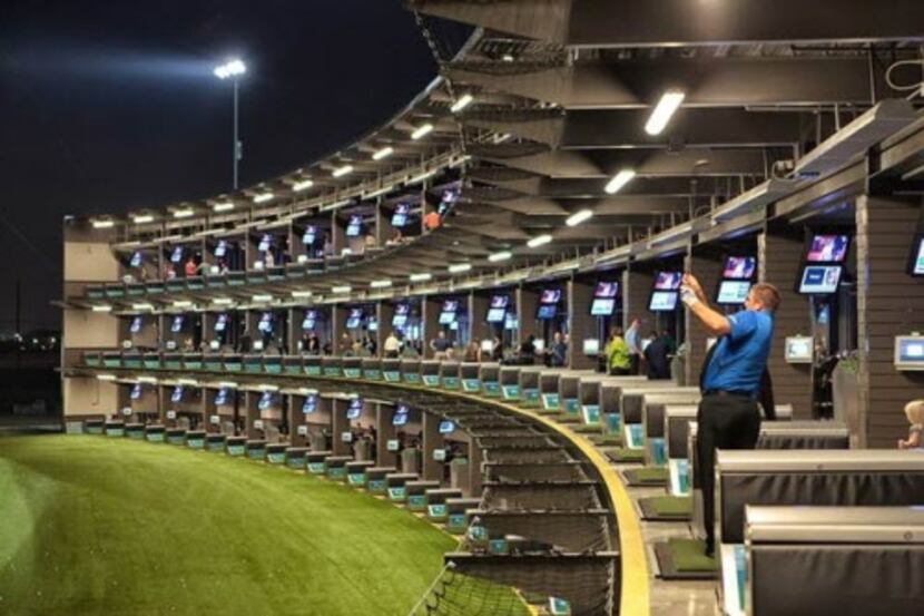 Golfer swinging on the tee line at Topgolf The Colony