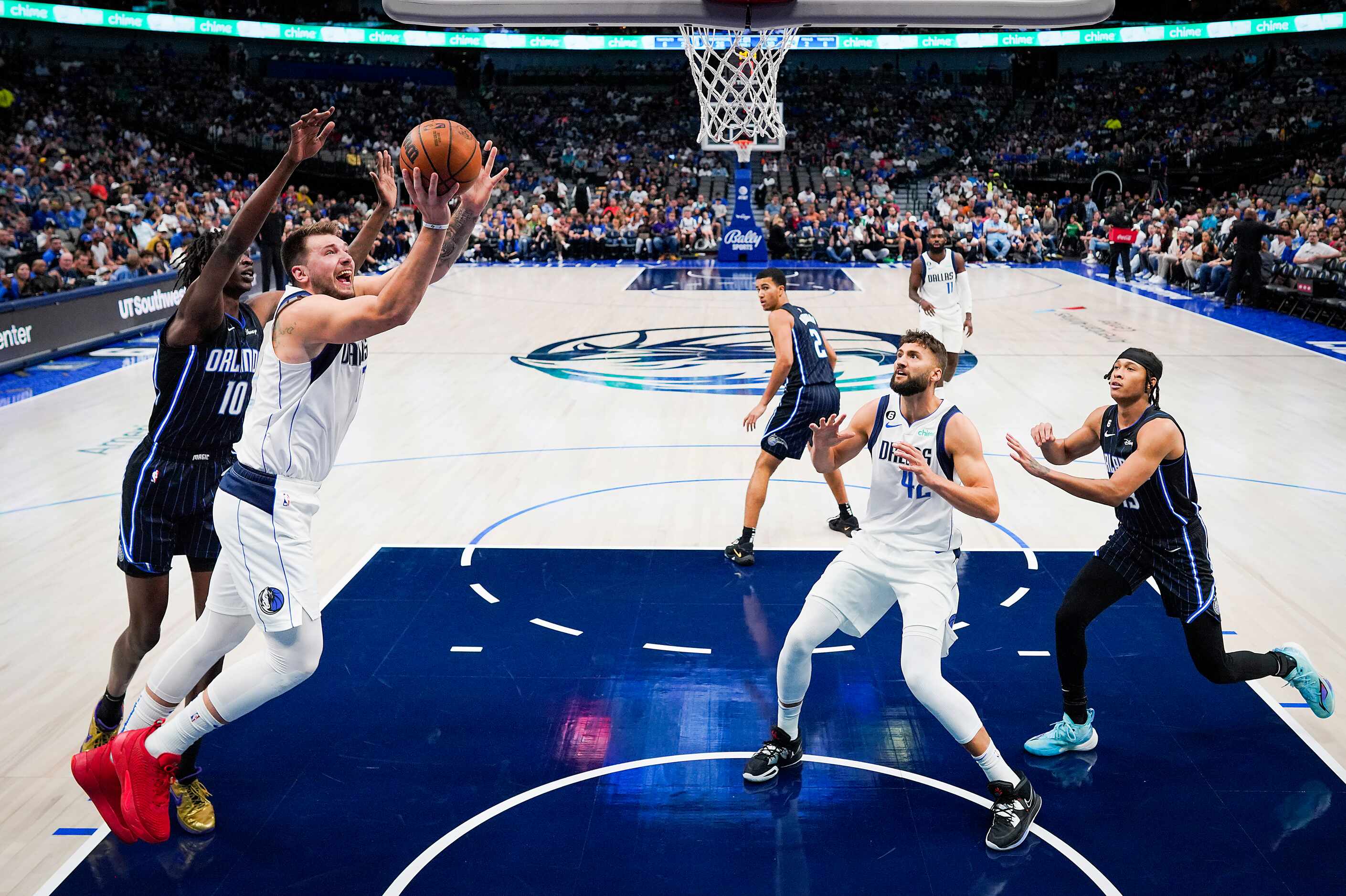 Dallas Mavericks guard Luka Doncic (77) shoots past Orlando Magic center Bol Bol (10) during...