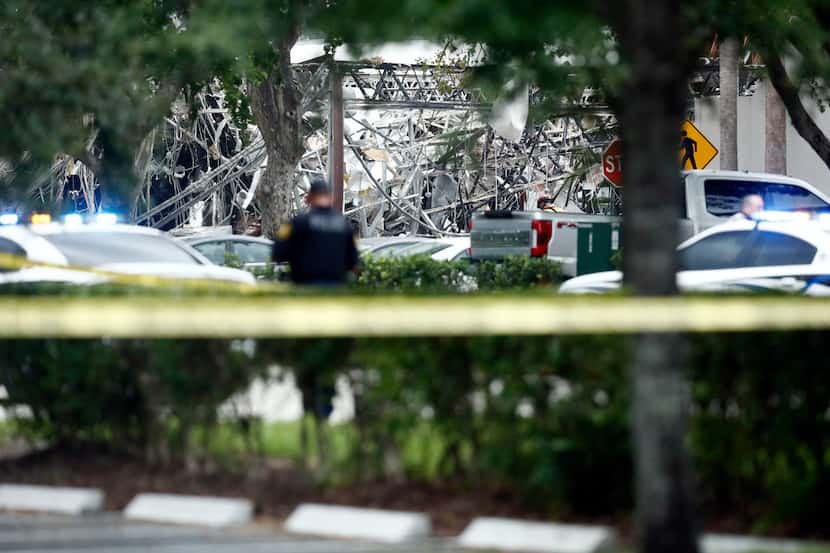 A police officer guards the area after an explosion Saturday in Plantation, Fla.  Several...