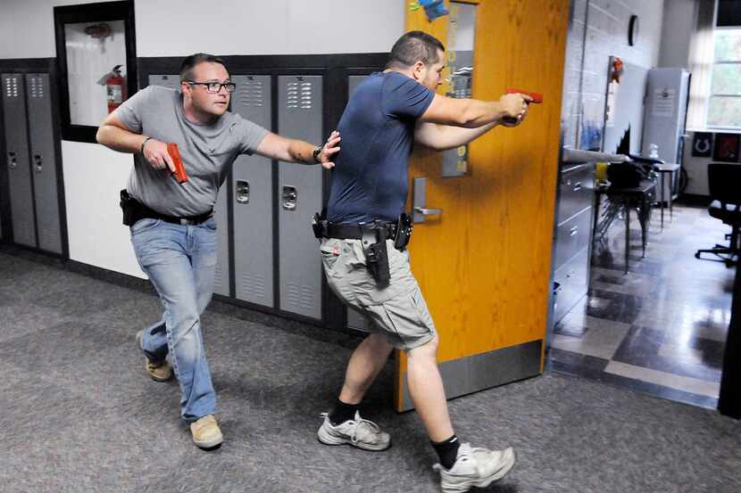 Justin Royse, left, and Dakota Steele practice moving down a hallway during active shooter...