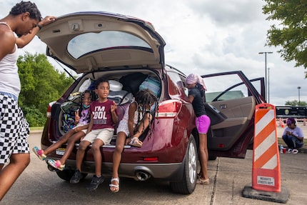 Arthur Washington (left) speaks with his children, Ava, 3, Arthur Jr., 4, and Addison, 5, as...