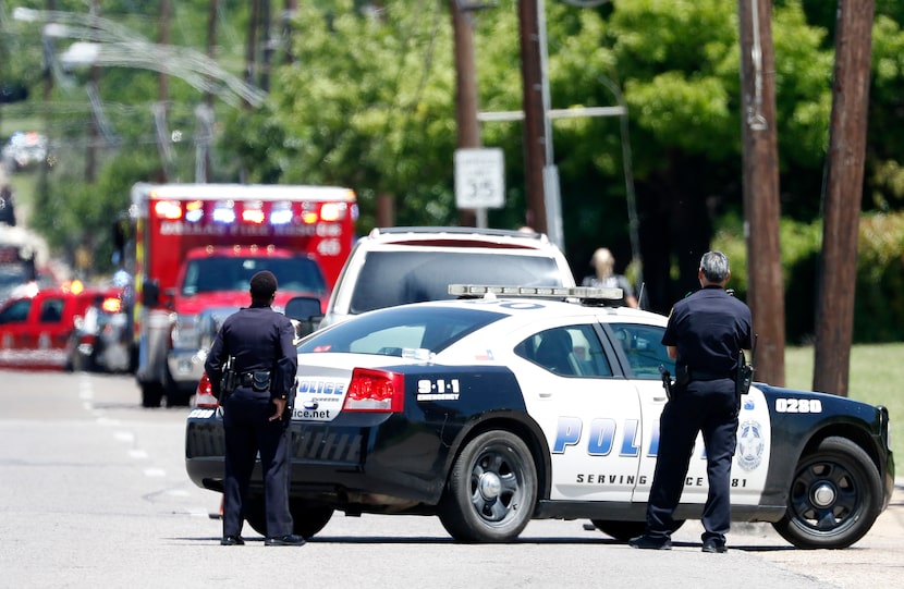 Dallas Police Officers work on the active shooting scene on Dolphin Road in Dallas, Monday,...