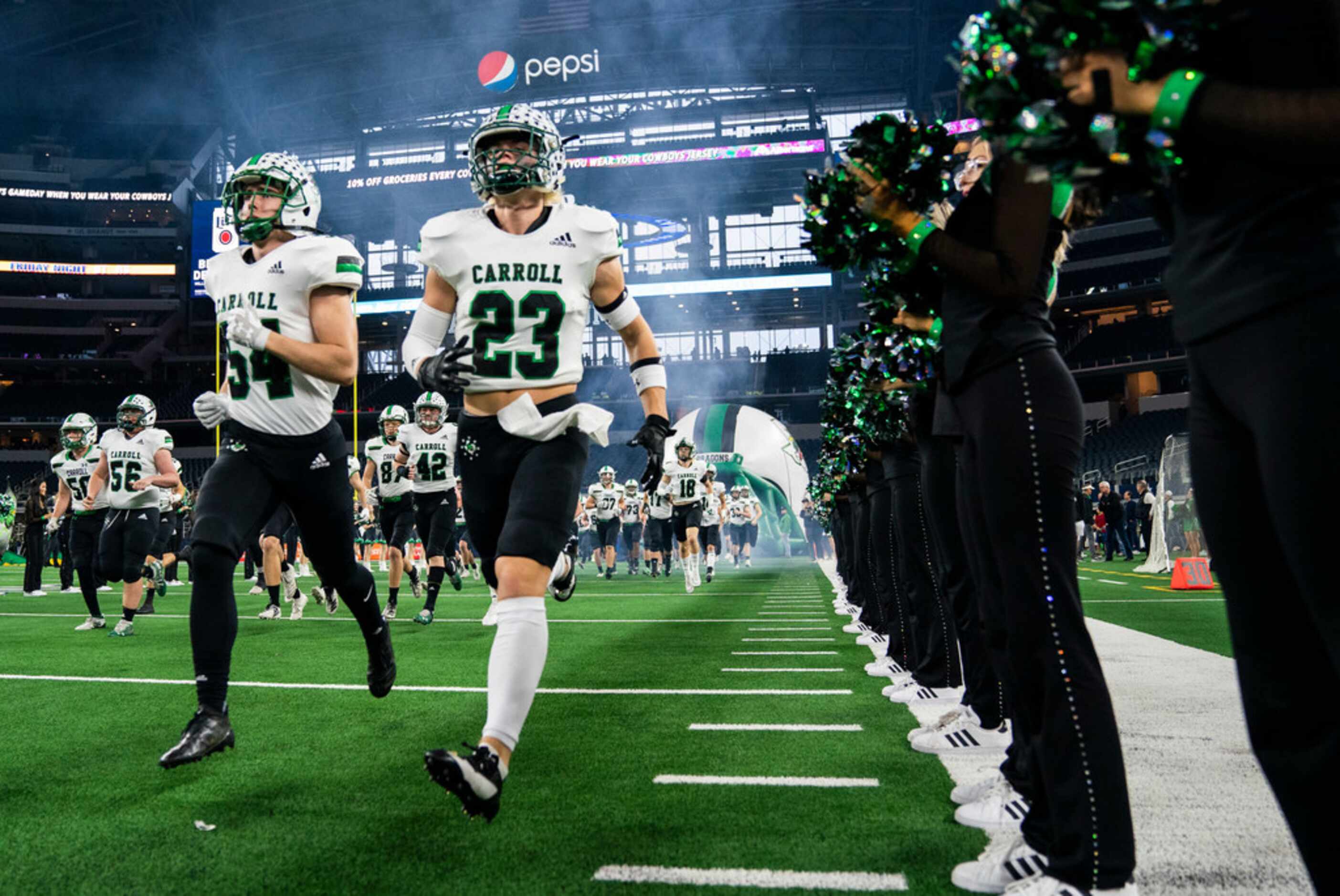 Southlake Carroll football players enter the field before a Class 6A Division I area-round...